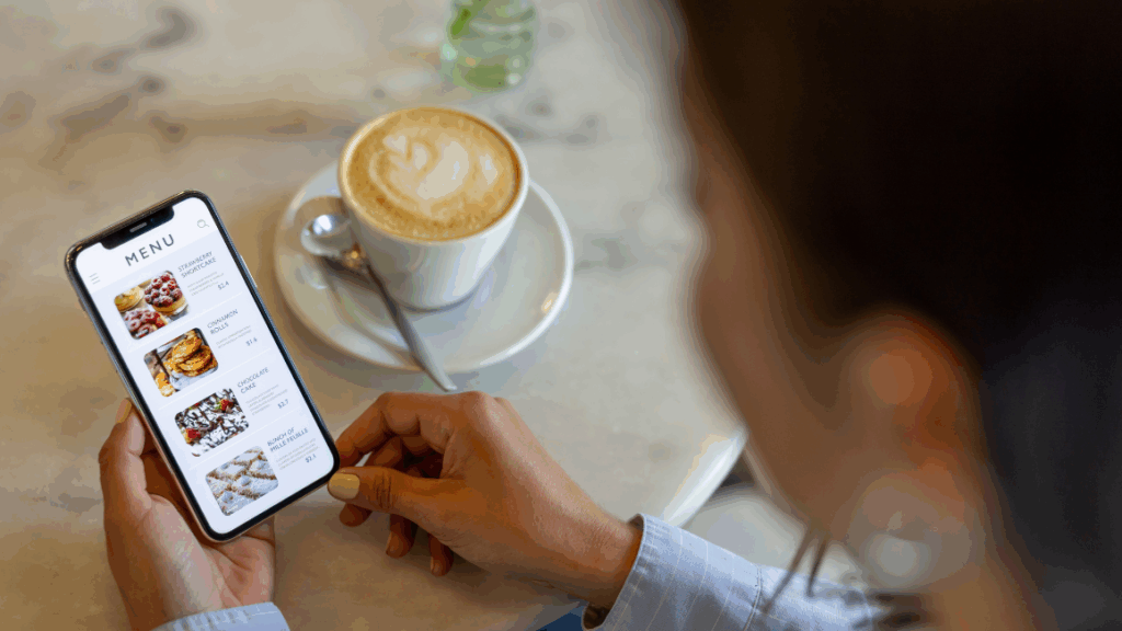 Person holding a mobile phone with a digital menu shown